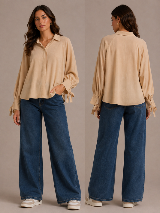 Beige Damenbluse mit langen Ärmeln, Hemdkragen und dekorativen Bindebändern an den Manschetten, kombiniert mit weiter Jeans